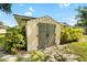Exterior view of a backyard storage shed surrounded by lush landscaping and a stone pathway at 2208 Deerbrook Dr, Lakeland, FL 33811