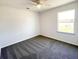 Bright bedroom featuring a ceiling fan, large window, and plush carpeting at 2521 Sunset Dr, Winter Haven, FL 33881