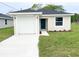 Charming single-story home with a well-manicured lawn, a driveway, and a blue front door at 2521 Sunset Dr, Winter Haven, FL 33881