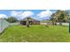 A spacious backyard with a white fence, a screened enclosure, storage shed, and a fire pit at 2932 Blackwater Oaks Dr, Mulberry, FL 33860