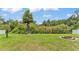 Expansive backyard featuring lush green grass, mature trees, and a charming fire pit for outdoor gatherings at 2932 Blackwater Oaks Dr, Mulberry, FL 33860