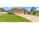 A view of the home's exterior showcasing a two-car garage and lush green lawn at 2932 Blackwater Oaks Dr, Mulberry, FL 33860
