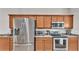 Stainless steel refrigerator, microwave, range, and oven complement the warm wood cabinets at 2932 Blackwater Oaks Dr, Mulberry, FL 33860