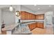 Kitchen with granite countertops, stainless steel sink, and wooden cabinetry with views to laundry room at 2932 Blackwater Oaks Dr, Mulberry, FL 33860