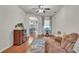 Bright living room features hardwood floors, ceiling fan, large window, and wood furniture at 2932 Blackwater Oaks Dr, Mulberry, FL 33860