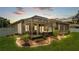 Outdoor living space with hot tub, patio, and screened enclosure, surrounded by manicured landscaping at 2932 Blackwater Oaks Dr, Mulberry, FL 33860