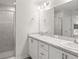 Bright bathroom featuring dual sinks, white cabinets, and a glass-enclosed shower at 3167 Laurel Oak Ln, Winter Haven, FL 33884