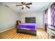 Bedroom features wood floors, a ceiling fan, a wood bed frame, and natural light from the window at 3542 Raintree Ct, Lakeland, FL 33803