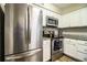 Modern kitchen featuring stainless steel appliances, including a large refrigerator, and white cabinets with granite countertops at 3542 Raintree Ct, Lakeland, FL 33803