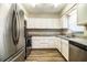 Updated kitchen with stainless steel appliances, white cabinets, granite countertops, and luxury vinyl plank flooring at 3542 Raintree Ct, Lakeland, FL 33803