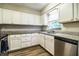 Bright kitchen with white cabinets, granite countertops, stainless steel appliances, and wood-style flooring for a modern look at 3542 Raintree Ct, Lakeland, FL 33803