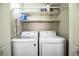 A functional laundry room featuring a modern washer and dryer with built-in shelving at 3542 Raintree Ct, Lakeland, FL 33803