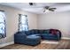 Living room featuring a comfortable, oversized blue sectional couch, hardwood floors, and two ceiling fans at 3542 Raintree Ct, Lakeland, FL 33803