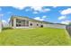 Backyard featuring lush lawn, a fenced perimeter, and the home's screened patio at 4143 Red Fern Ln, Lakeland, FL 33811