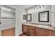Bathroom features a double vanity with dark wood cabinets and a walk-in closet with shelves at 4143 Red Fern Ln, Lakeland, FL 33811