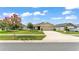 A well-maintained single-Gathering home showcasing a lush green lawn, mature tree, and paved driveway at 4143 Red Fern Ln, Lakeland, FL 33811