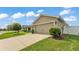 Home's exterior showing the driveway, a two-car garage, landscaping, and partial fencing on the property at 4143 Red Fern Ln, Lakeland, FL 33811