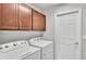 Convenient laundry room with modern washer and dryer units and upper cabinets at 4143 Red Fern Ln, Lakeland, FL 33811