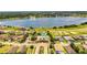An aerial view of a neighborhood with a pool, tennis court, a lake, and residential houses at 4222 Juliana Lake Dr, Auburndale, FL 33823