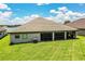 Beautiful home featuring a well-maintained lawn, a screened patio, and a tranquil waterfront view in the background at 4222 Juliana Lake Dr, Auburndale, FL 33823