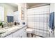 Cozy bathroom with granite countertop, striped shower curtain, and white fixtures at 4222 Juliana Lake Dr, Auburndale, FL 33823
