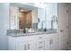 Bathroom featuring double vanity with granite countertop, framed mirror, and tiled shower at 4222 Juliana Lake Dr, Auburndale, FL 33823