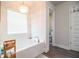 Bathroom showcasing a soaking tub beneath a chandelier-style light fixture and natural light at 4222 Juliana Lake Dr, Auburndale, FL 33823
