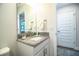 Bright bathroom featuring a granite countertop, single sink, and white cabinets, offering a clean, modern design at 4222 Juliana Lake Dr, Auburndale, FL 33823