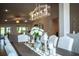 Elegant dining room with decorative chandelier, table centerpiece, and views of the living area at 4222 Juliana Lake Dr, Auburndale, FL 33823