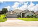 Beautiful single-Gathering home featuring a two-car garage, mature landscaping and well-manicured lawn at 4222 Juliana Lake Dr, Auburndale, FL 33823