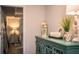 Hallway view of decorative turquoise cabinet with display items, hallway leads to bright rooms at 4222 Juliana Lake Dr, Auburndale, FL 33823