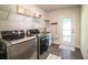 Well-equipped laundry room featuring modern washer and dryer, a utility sink, and an exterior door to the backyard at 4222 Juliana Lake Dr, Auburndale, FL 33823