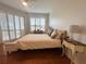 Bright bedroom with wood floors, a decorative lamp, and shuttered windows at 443 Enclave Pl # 0, Lakeland, FL 33803