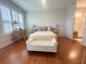 Bright bedroom with wood floors, white furniture, ensuite bath, and shuttered windows at 443 Enclave Pl # 0, Lakeland, FL 33803