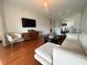 Bright living room features hardwood floors, modern furniture, and an open floor plan leading to the dining area at 443 Enclave Pl # 0, Lakeland, FL 33803