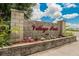 Inviting entrance to Village Park with stone signage and colorful landscaping, creating a warm welcome at 451 Village Sw Cir, Winter Haven, FL 33880