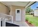 Exterior entrance featuring a ramp and painted door leading to the well-maintained backyard at 451 Village Sw Cir, Winter Haven, FL 33880