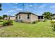 Exterior home view showcasing a well-maintained yard and central air conditioning unit at 451 Village Sw Cir, Winter Haven, FL 33880