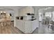 Bright kitchen featuring white cabinetry, laminate flooring and a dining area at 451 Village Sw Cir, Winter Haven, FL 33880