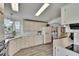 Spacious kitchen featuring white cabinets, modern appliances, and laminate wood flooring at 451 Village Sw Cir, Winter Haven, FL 33880
