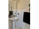 Powder room featuring pedestal sink, a decorative mirror, and black towel at 4665 Sw 40Th Pl, Ocala, FL 34474