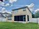 Exterior view of the home showing a screen porch, fenced yard and blue skies at 4665 Sw 40Th Pl, Ocala, FL 34474