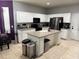 Bright kitchen featuring white cabinets, stainless steel appliances, a kitchen island, and neutral countertops at 4665 Sw 40Th Pl, Ocala, FL 34474