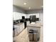 Bright kitchen featuring white cabinets, stainless steel appliances, a kitchen island, and neutral countertops at 4665 Sw 40Th Pl, Ocala, FL 34474