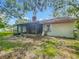 The home's rear exterior includes the sunroom, chimney, and roof at 4720 Wildflower Dr Dr, Lakeland, FL 33811