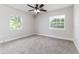 Bedroom with two windows, neutral carpet and walls, ceiling fan, and white trim at 508 Boger N Blvd, Lakeland, FL 33803