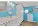 Stylish bathroom with white cabinets, a marble countertop, a round mirror, and bright blue walls at 5771 Macaw Pl, Lakeland, FL 33809
