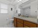 Bathroom featuring wood cabinets, a vanity with a stone countertop, a mirror, and white tile flooring at 5771 Macaw Pl, Lakeland, FL 33809