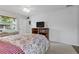 Bright bedroom featuring a floral comforter, ceiling fan, and a wooden bookshelf with a television at 5771 Macaw Pl, Lakeland, FL 33809