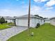 Exterior view of house with a patterned driveway and well-kept lawn at 5771 Macaw Pl, Lakeland, FL 33809